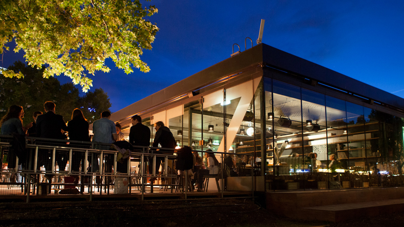 Nachtansicht des Restaurants und seiner leuchtenden Glaskubusarchitektur