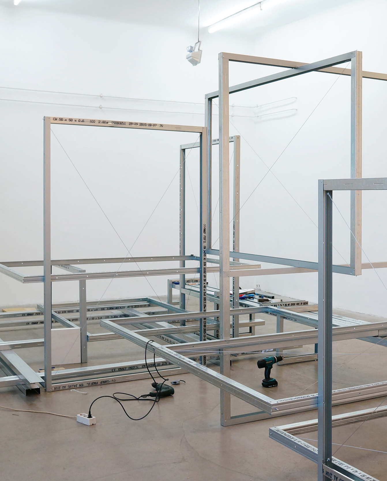 The raw construction of the exhibition display of aluminum frames that interlock to create a space-filling installation