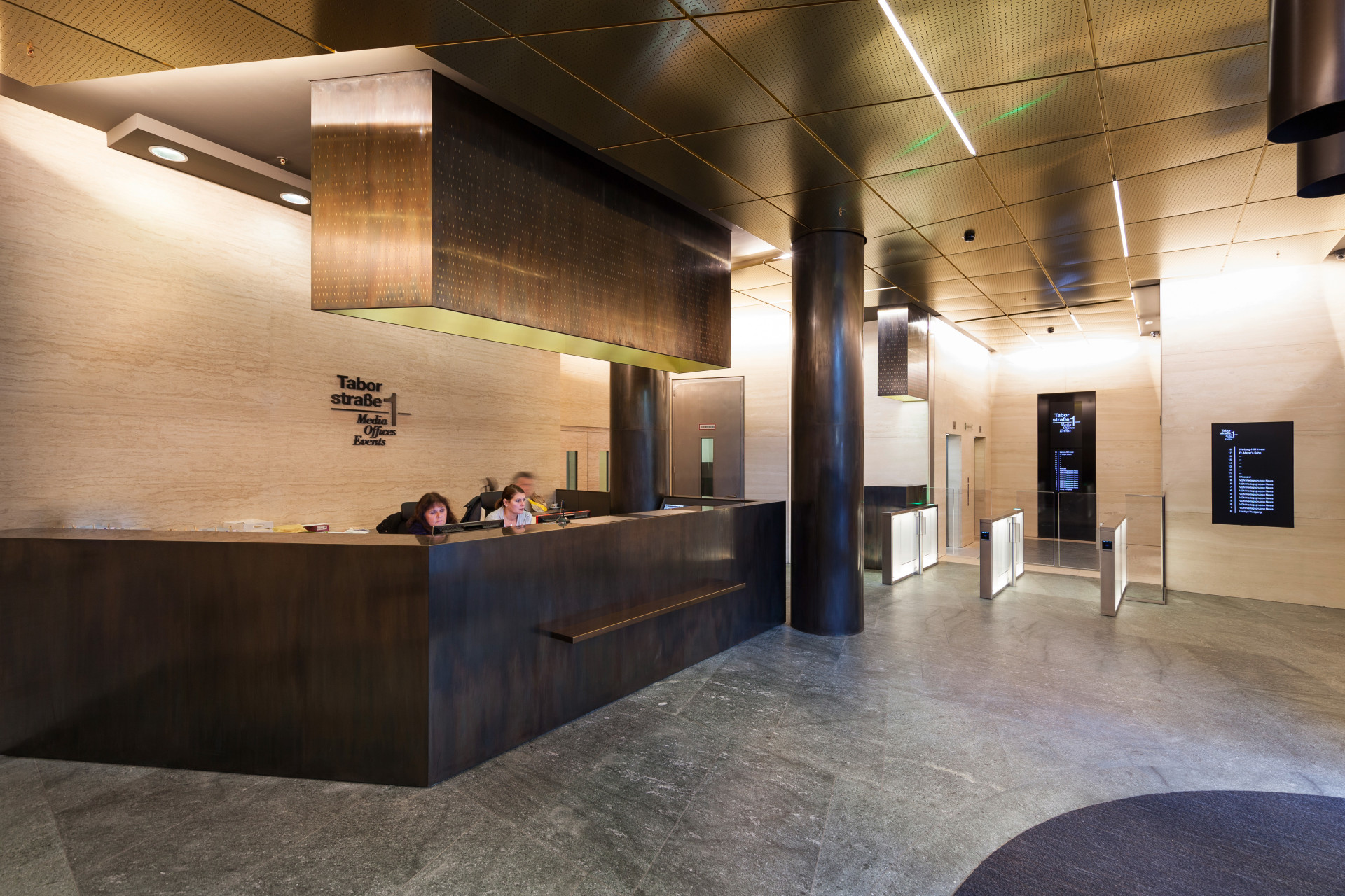 Entrance area of Taborstraße 1 with black reception desk and hanging gold cube as design element