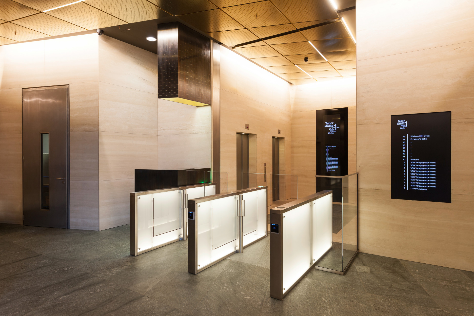 Entrance area to the offices with controlled passage lock with golden ceiling and black orientation system mounted on marble wall