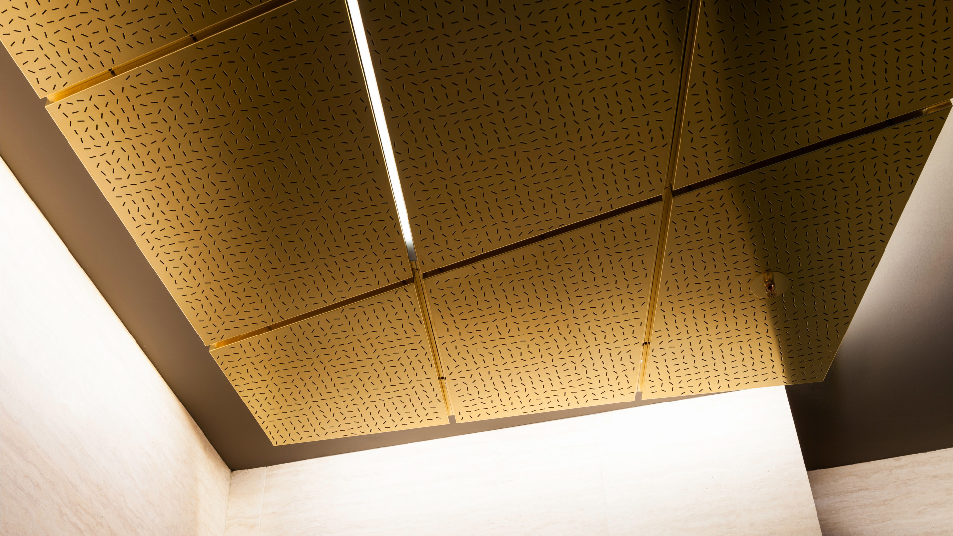 Eine goldene Decke in Aufsicht, mit Kassettenelementen aus Messing und Lichtstreifen