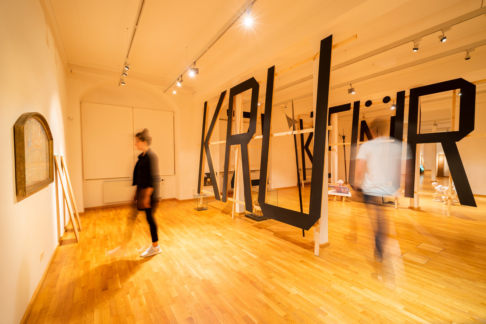 Exhibition space with an expansive typographic installation through which people walk