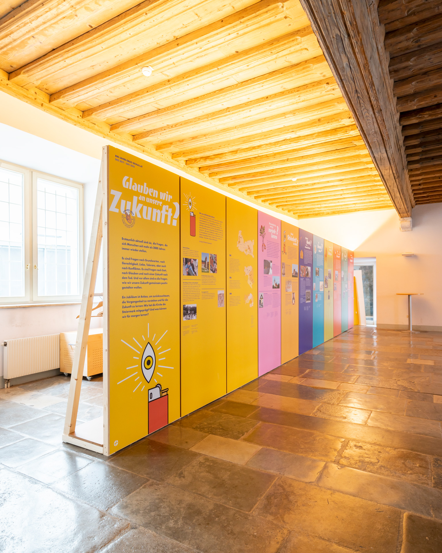 Exhibition view of a bright room, with erected MDF boards carrying the content directly printed on 