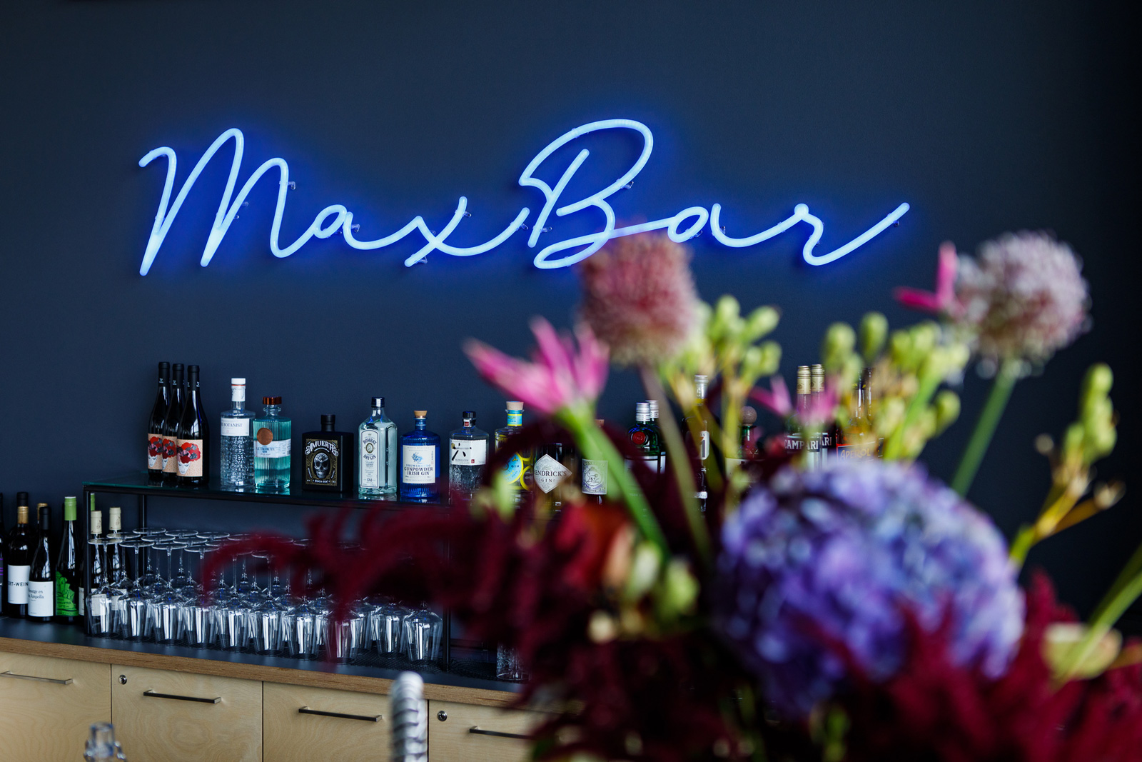 Die neue Bar im Max Café, mit blauer Wand, blauer Neonleuchte als Schriftzug und modernem Look
