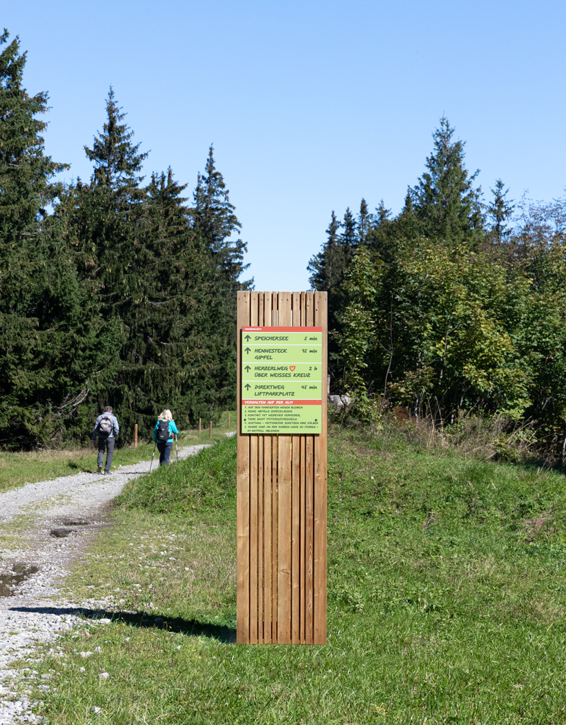 Wanderweg mit einer Orientierungs-Stele aus Holz im Vordergrund