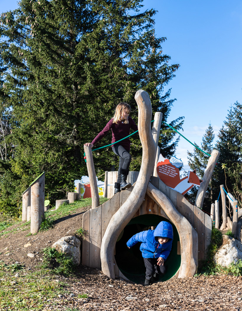 Kind auf einem Spielplatz mit einer Fuchsbau-Station, die das Leben von Füchsen erlebbar macht