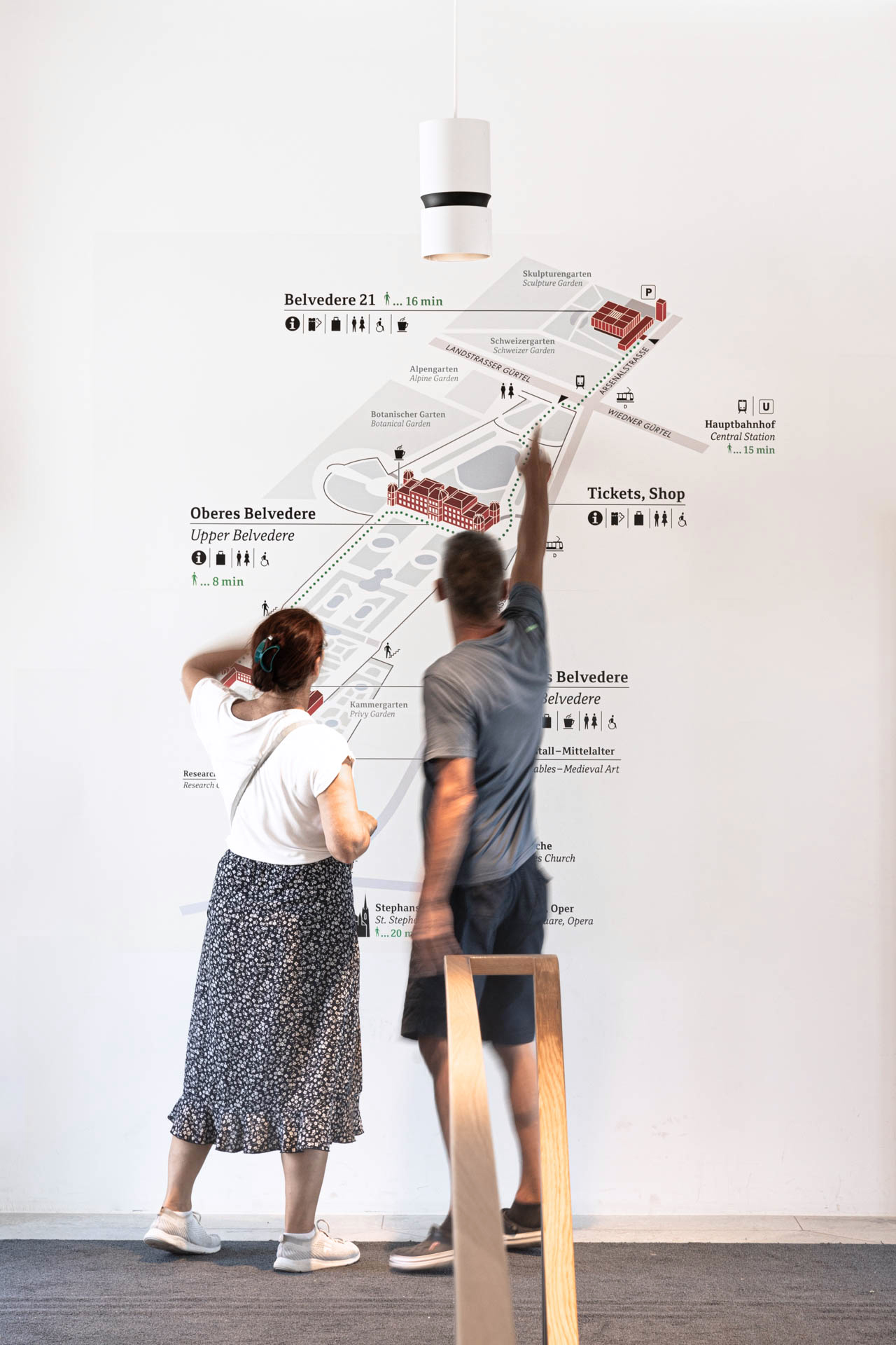 Two people standing in front of a human sized orientation map